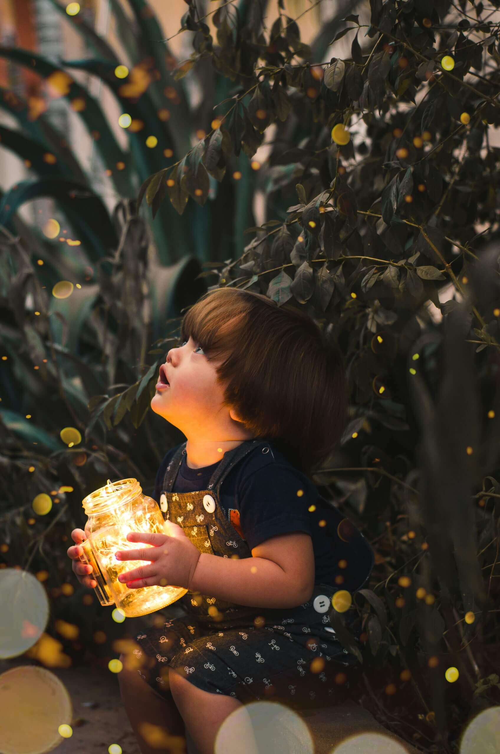 Niño agarrando un tarro de luz. 