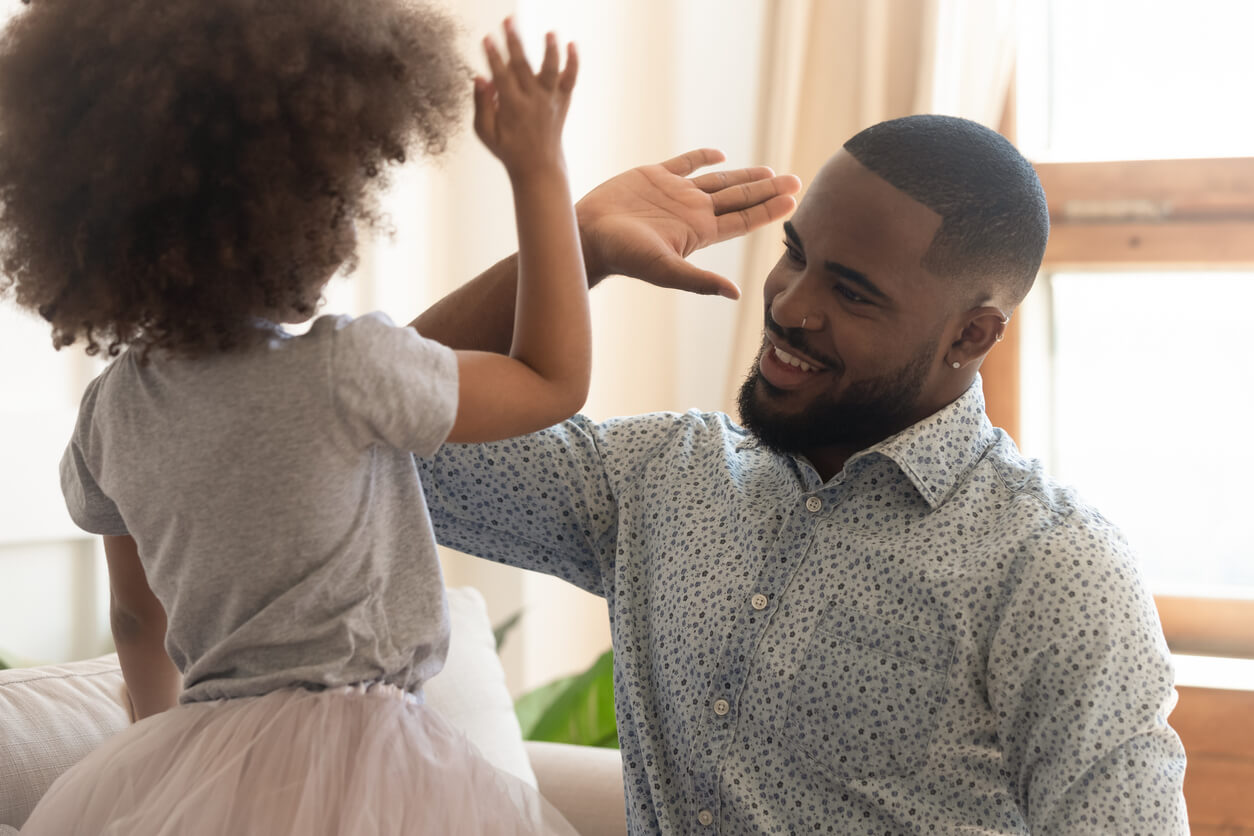 A father high-fiving his daughter.