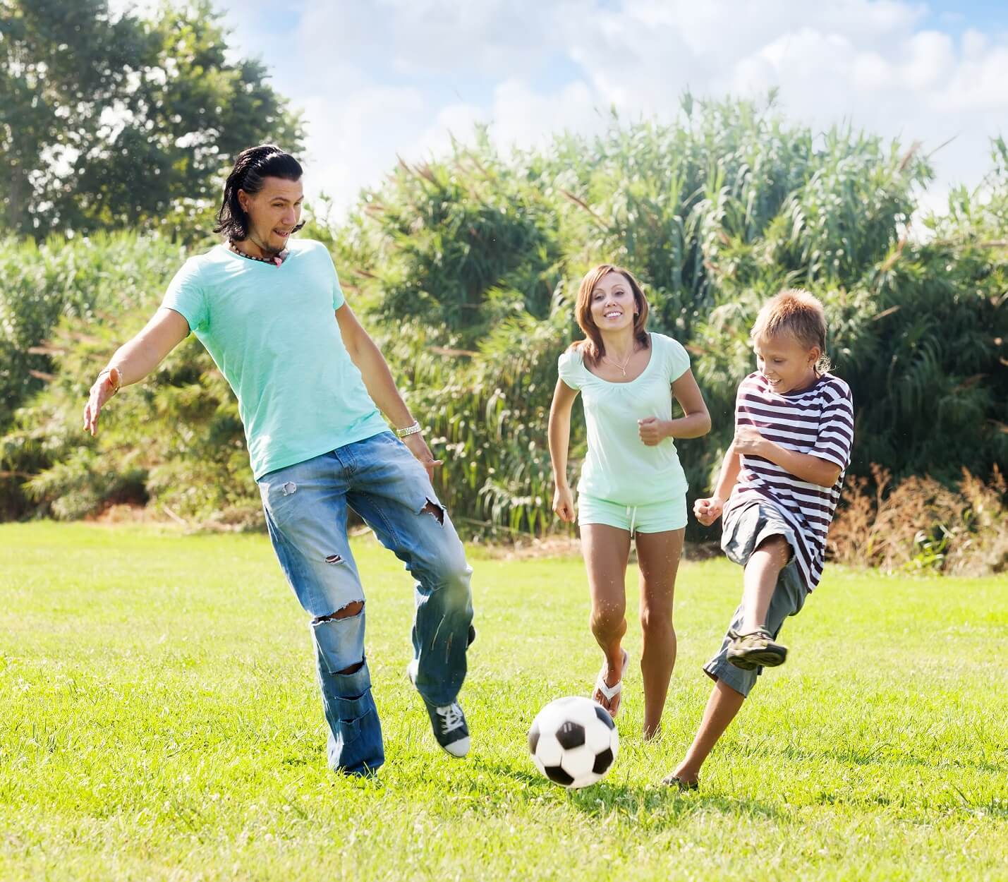 Parents playing soccer with their son.