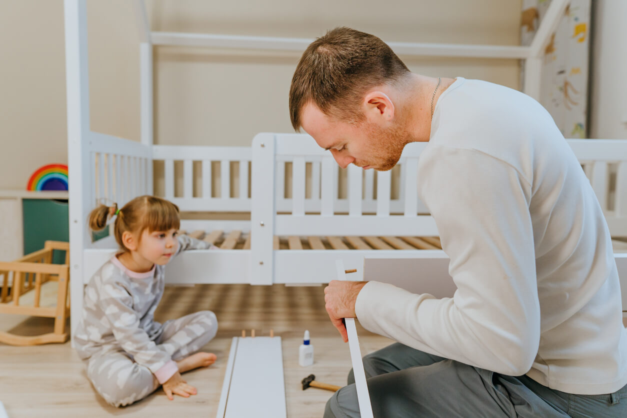 A father putting his daughters bed together.
