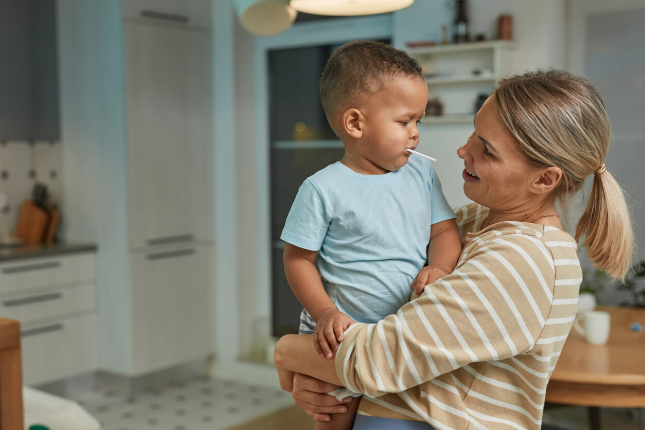 Une femme qui tient un jeune enfant dans ses bras.