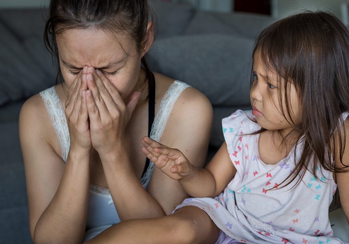 A toddler comforting her crying mother.