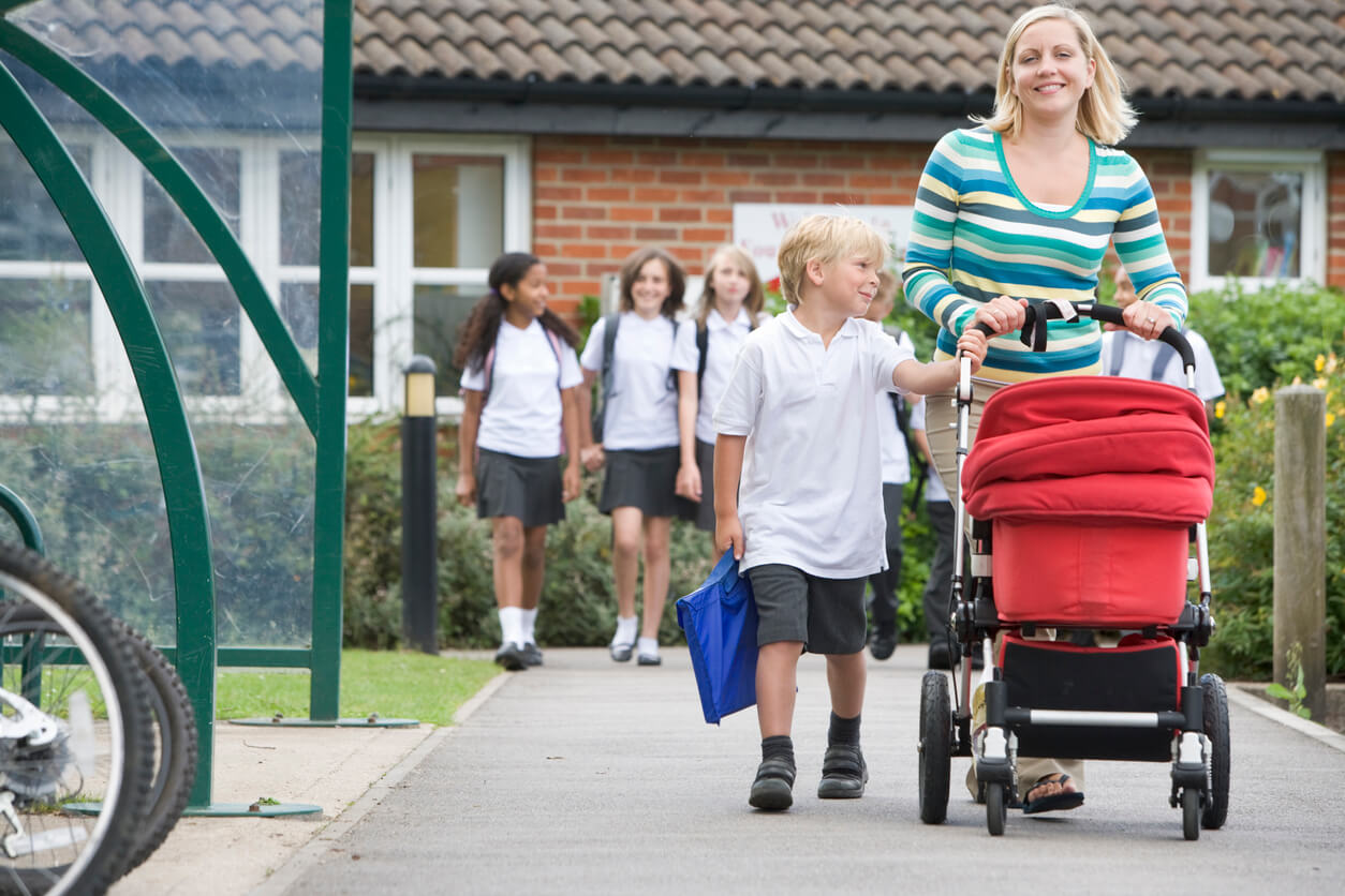 Une maman avec ses deux enfants qui rentrent de l'école.