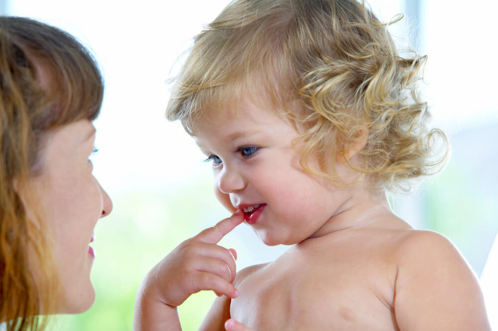 En mamma tittar sitt barn i ögonen.