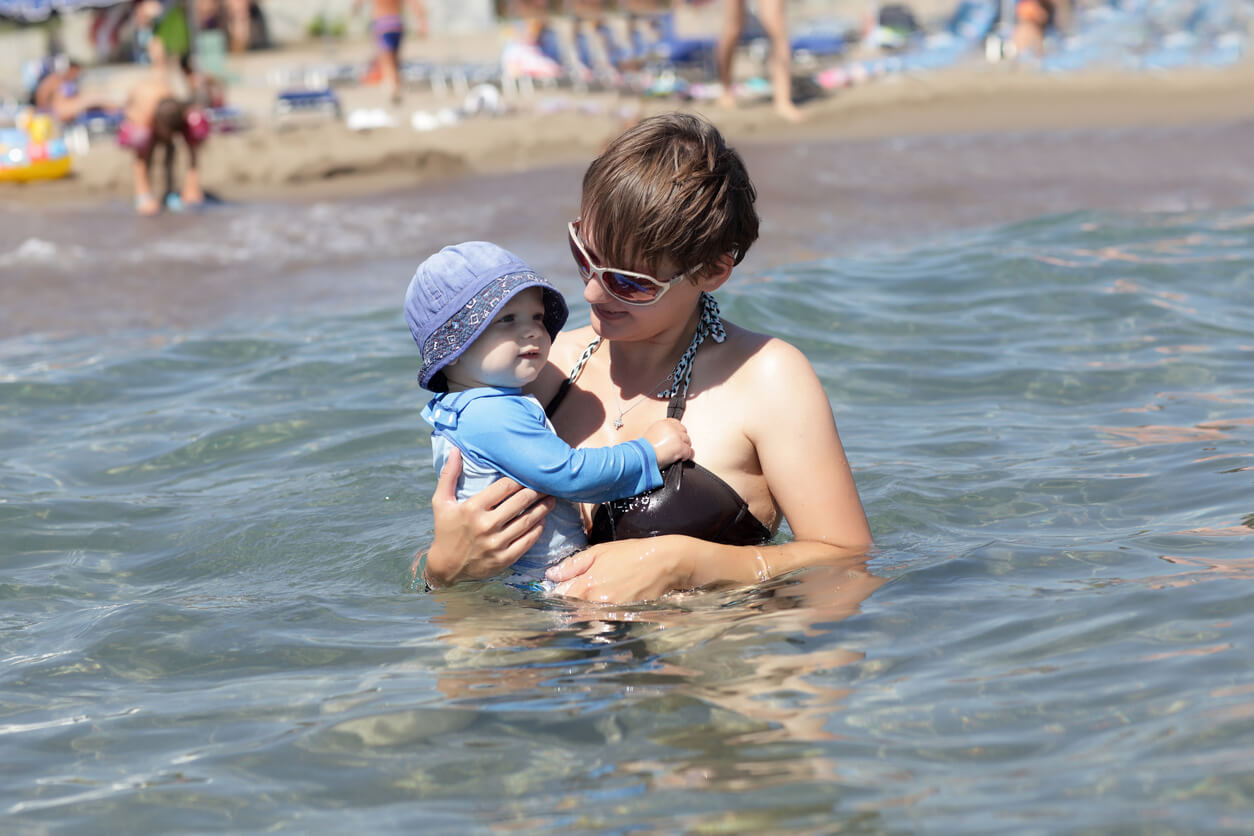 Äiti ui meressä vauvansa kanssa.