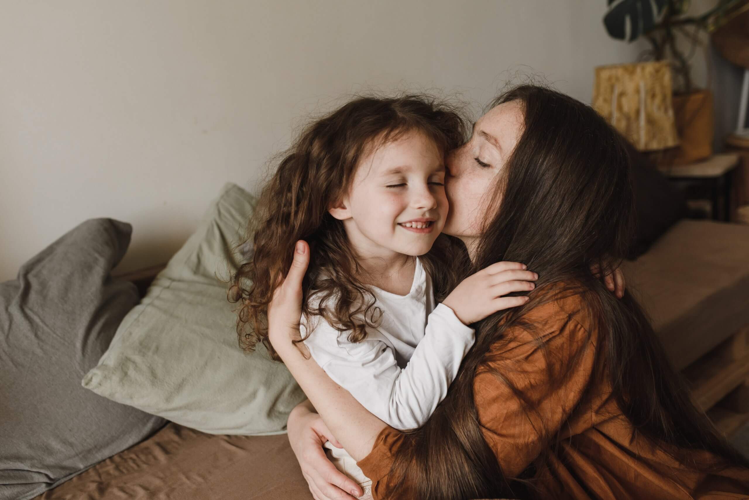 Niña feliz abrazando a su mamá