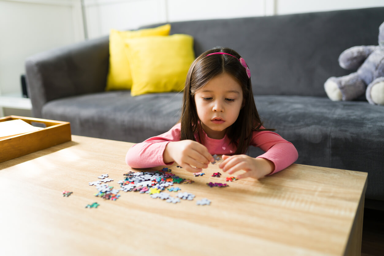 A young girl putting together a puzzle.