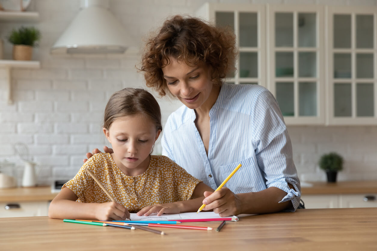 A woman coloring with her partner's daughter.