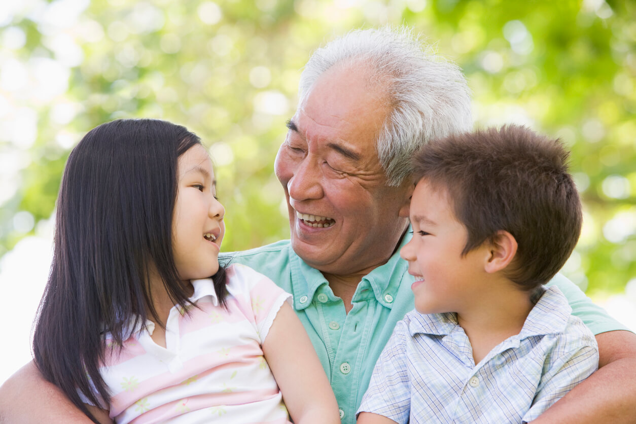 En japansk farfar med sina barnbarn i knät.