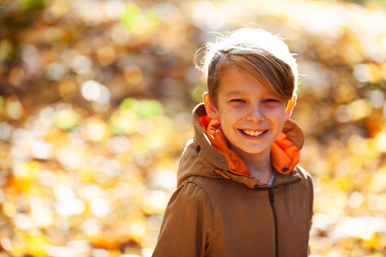 A boy walking outdoors in the fall.