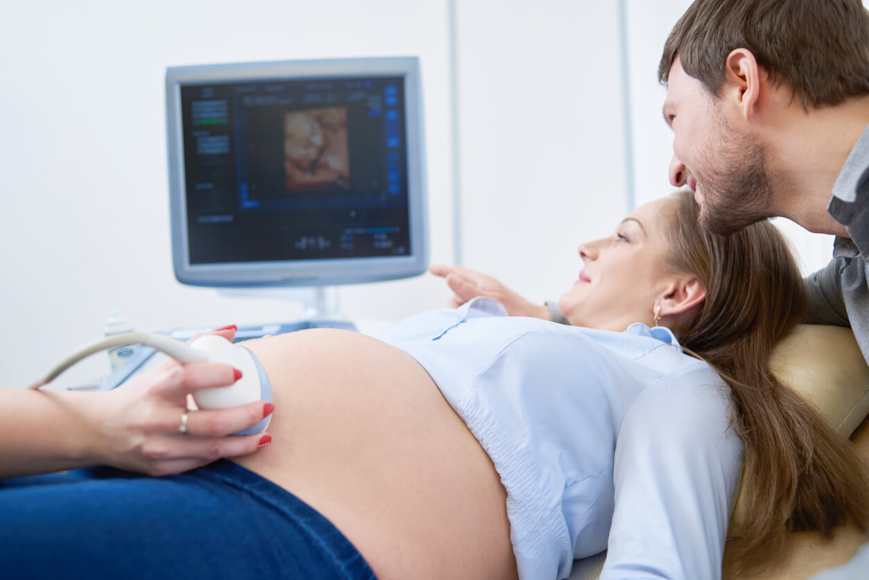 Mulher grávida realiza ultrassom com seu parceiro, pai, bebê pré-natal, estudos de saúde materno-infantil