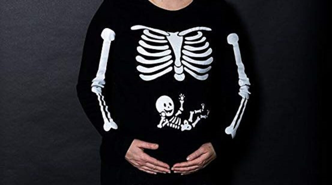 A pregnant woman wearing a skeleton shirt that also shows the skelaton of a baby on her belly.