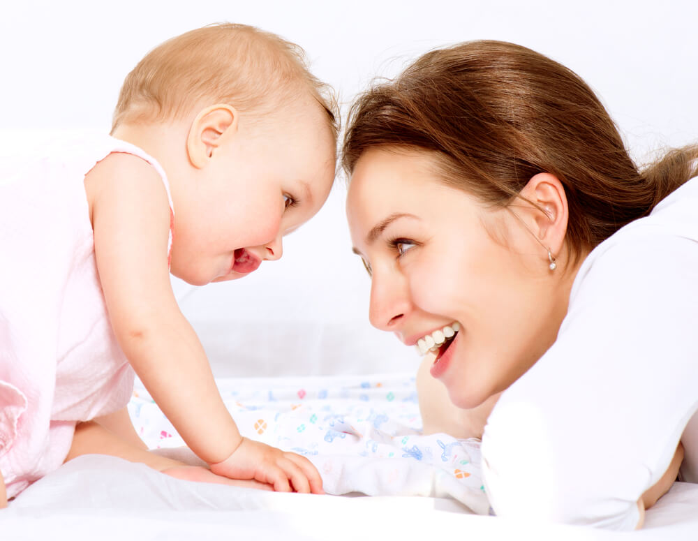 A mother playing with her baby girl.