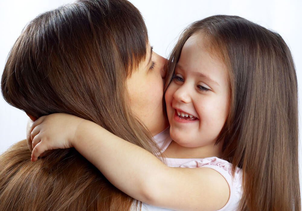 A mother hugging her little girl.