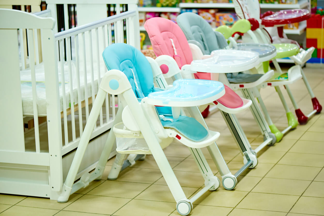 A crib and high chairs in a baby store.