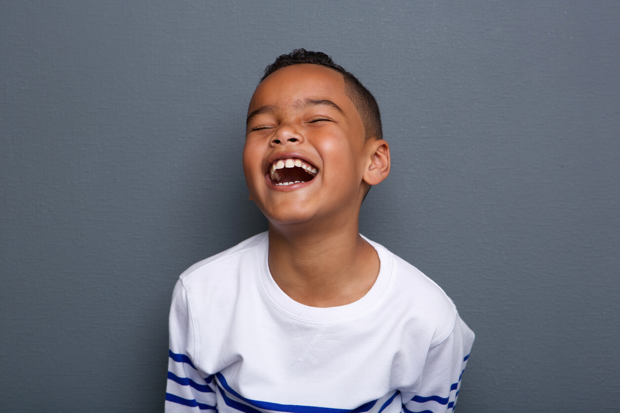 Et barn som ler og viser tenner.
