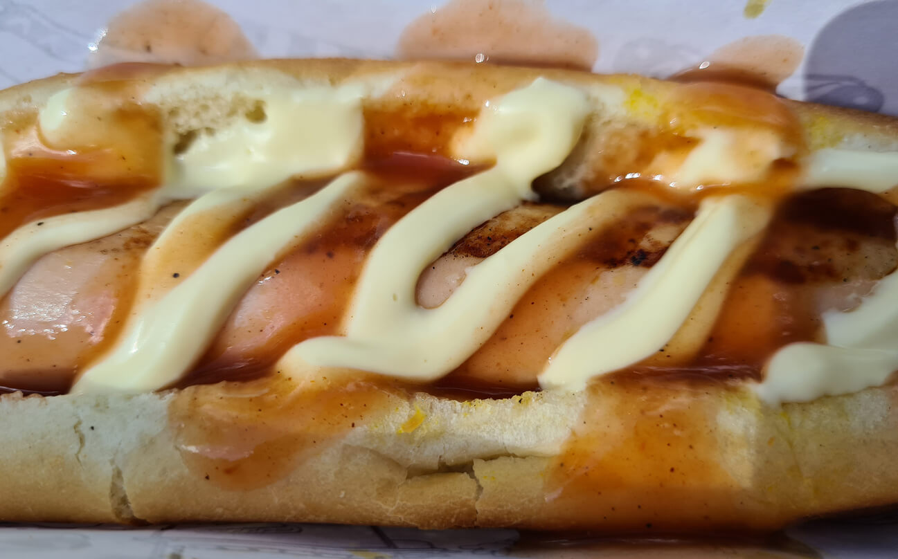 A hotdog with ketchup and mayonnaise.