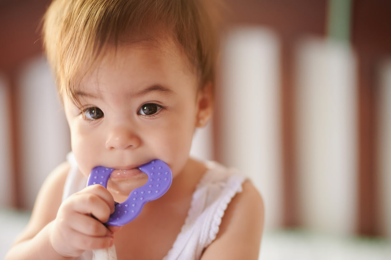 A baby chewing on a teether.