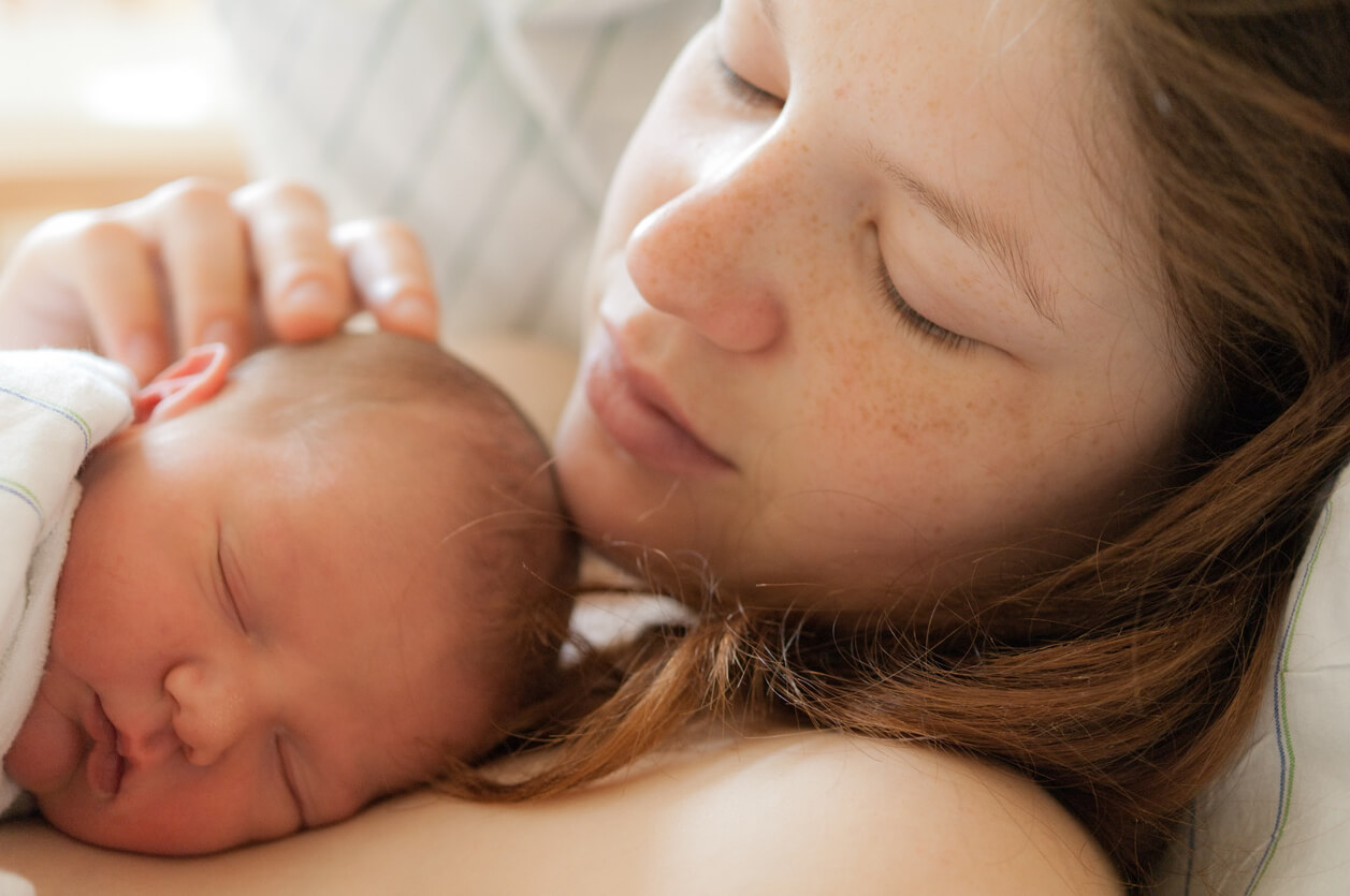 En mor och ett nyfött barn som delar hud-mot-hud-kontakt.