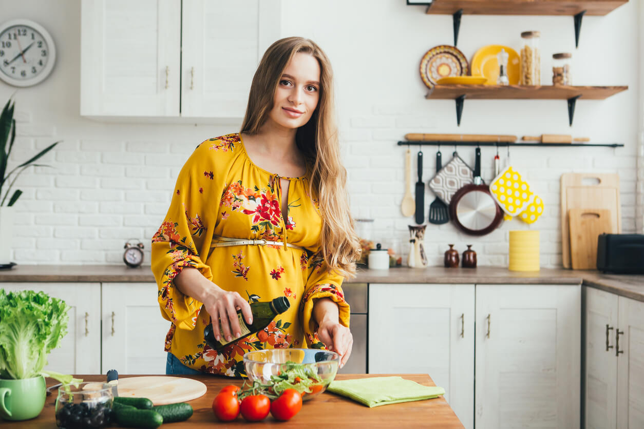 Een zwangere vrouw bereidt een gezonde salade