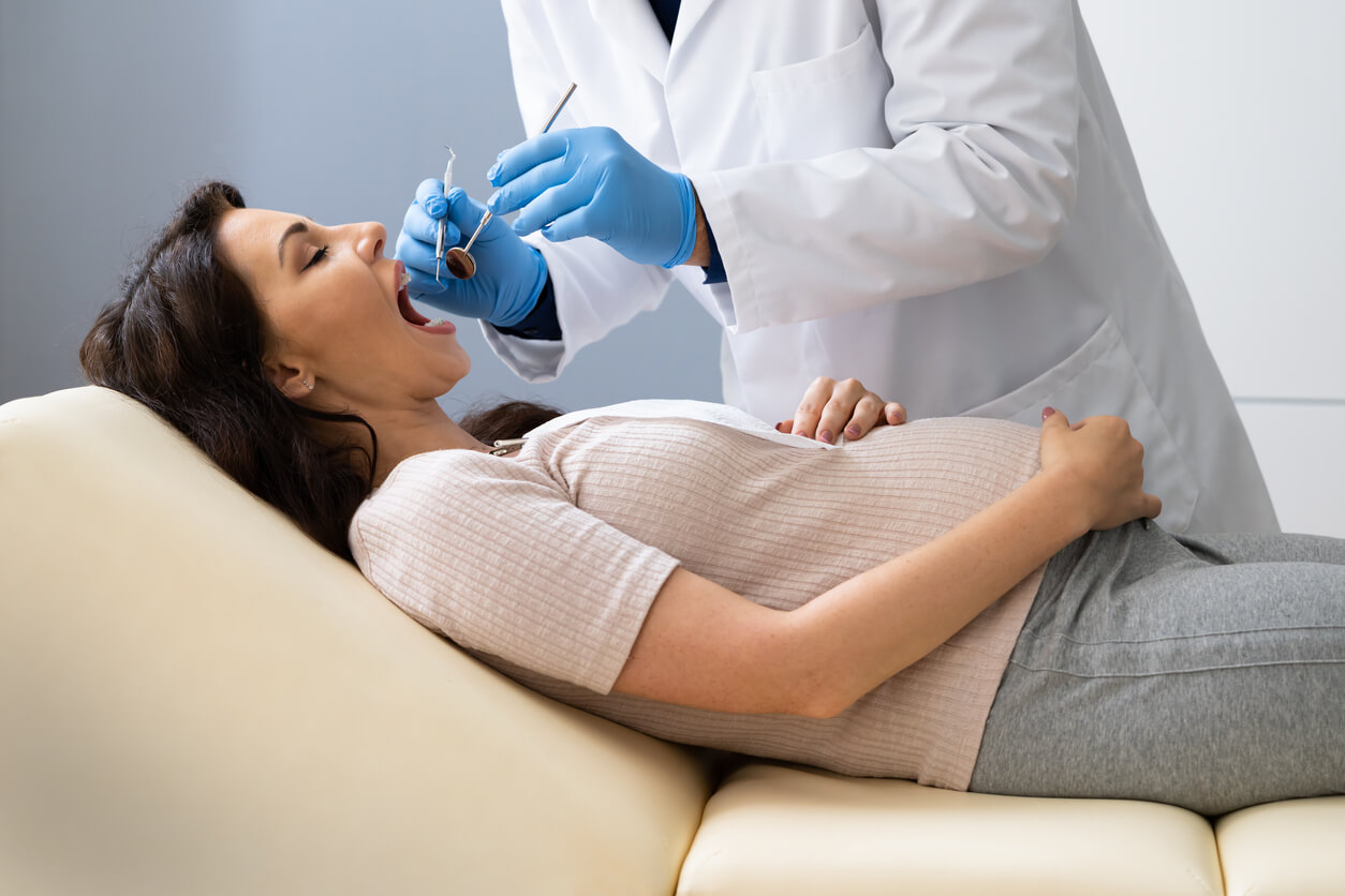 A pregnant woman visiting the dentist.