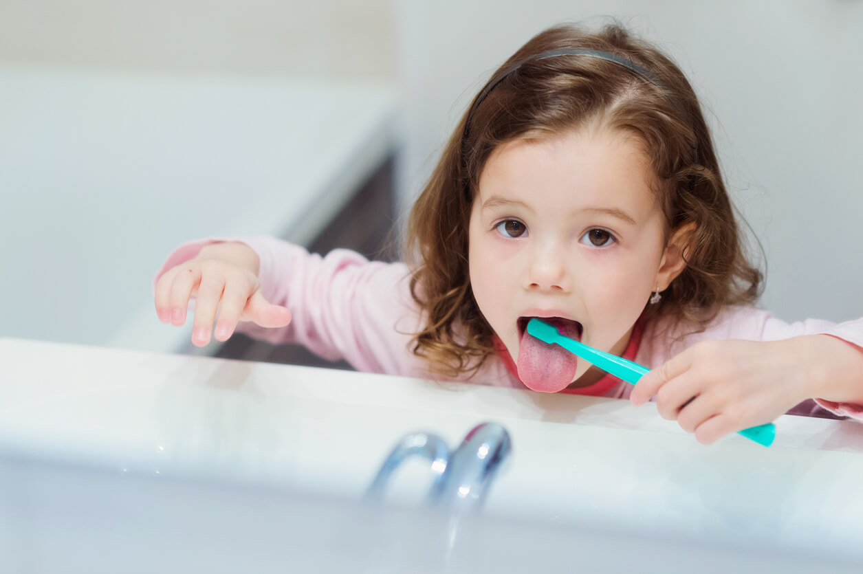 A toddler brushing her teeth.