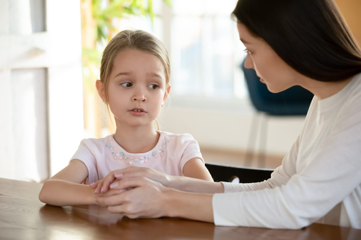 A little girl who's opening up to her mom about a difficult subject.