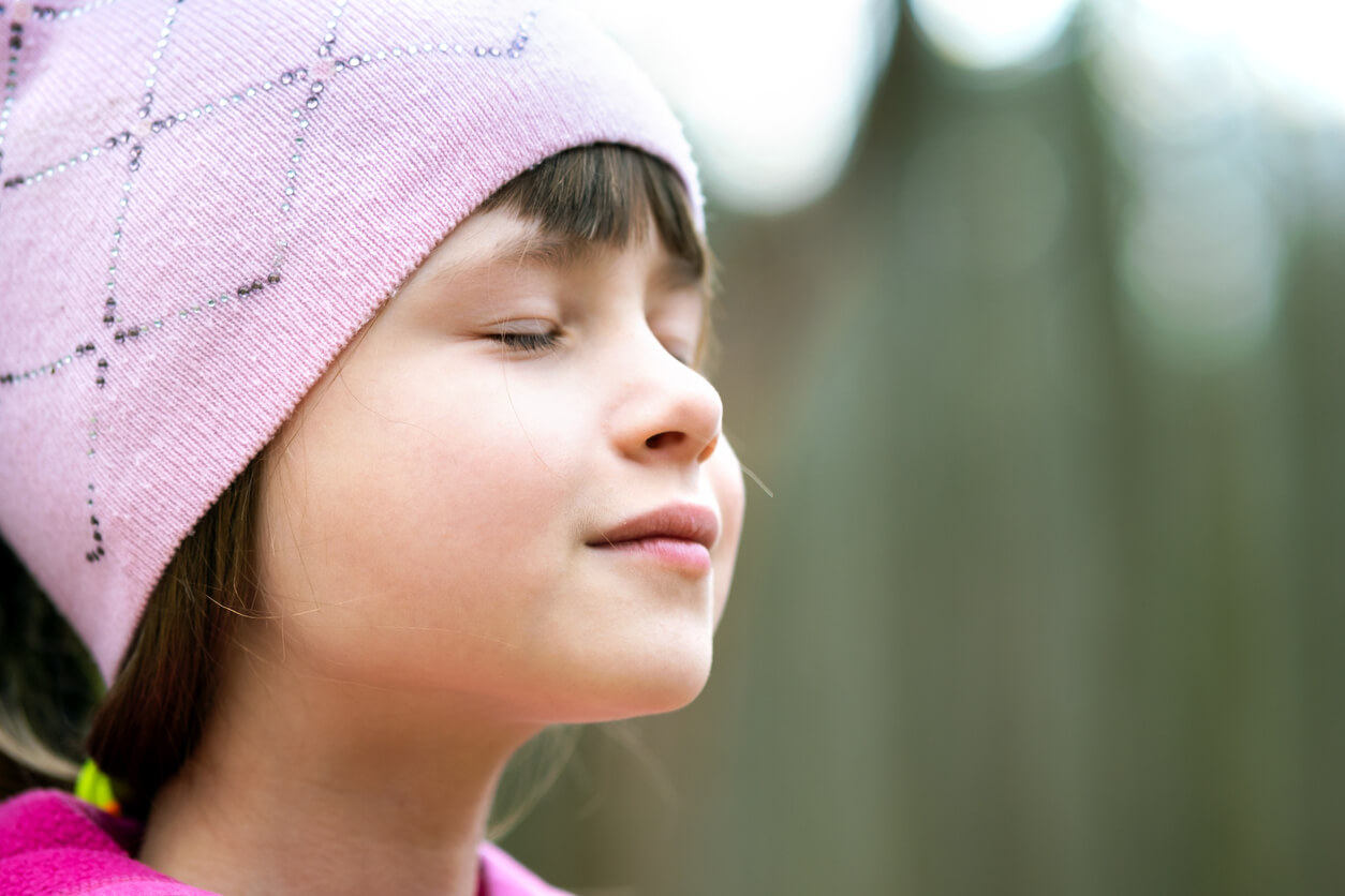 A young girl practicing breathing exercises.