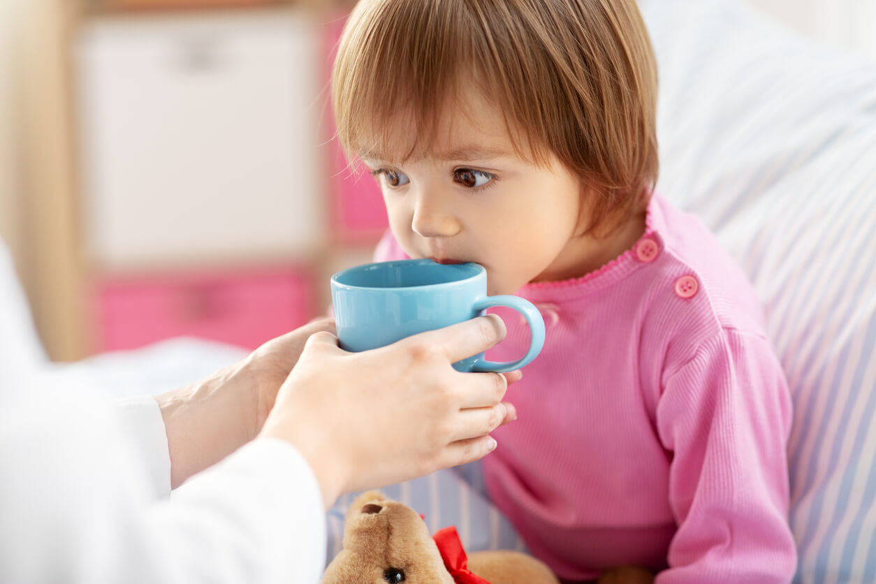 A toddler drinking from a coffee cup.
