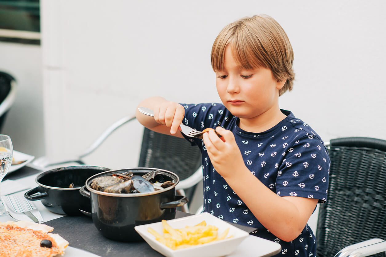 Et barn avskaller blåskjell.