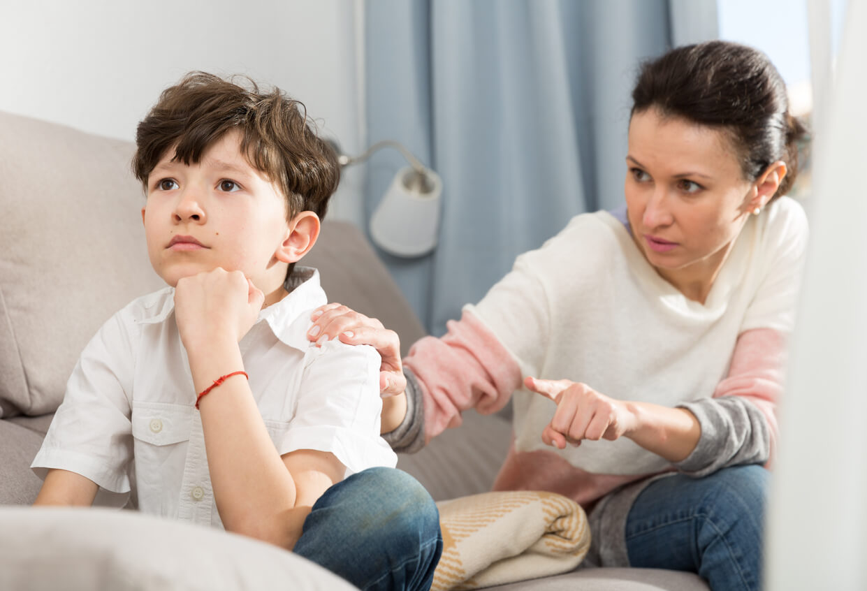 A child with his back to his mom, looking stone-faced.