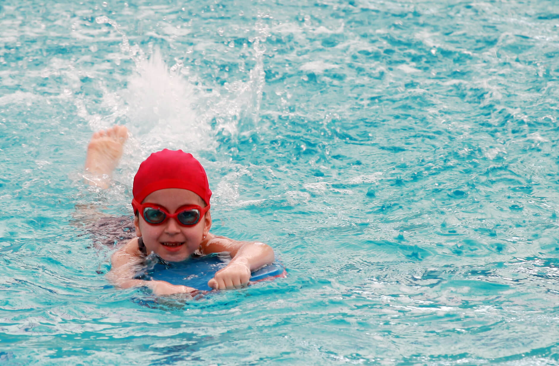 Et lite barn svømmer i et basseng.