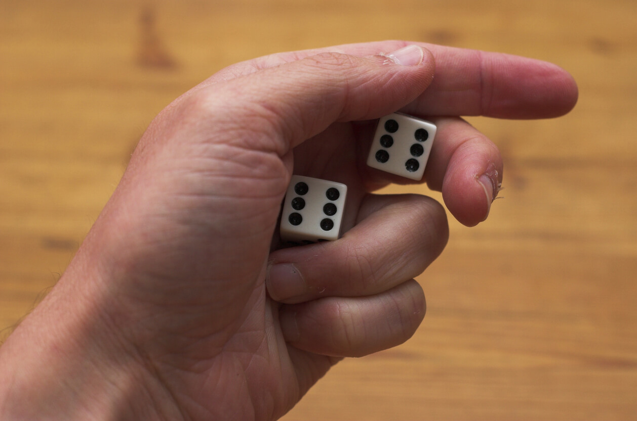 Deux dés dans une main.