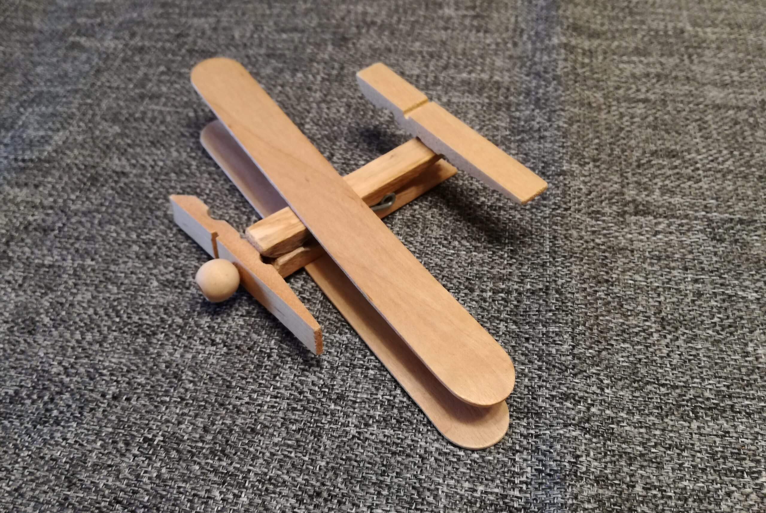An airplane made of wooden clothespins and popsicle sticks.
