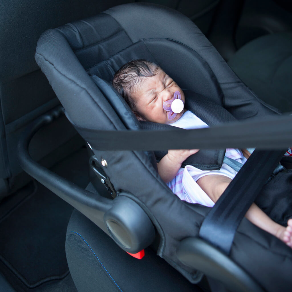 Un bébé qui pleure dans son siège auto. 