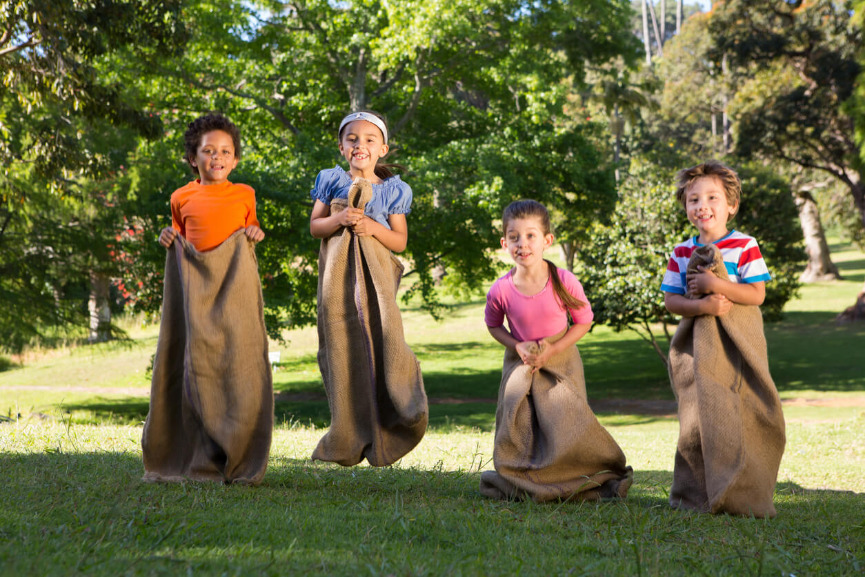 Des enfants qui font une course en sacs.