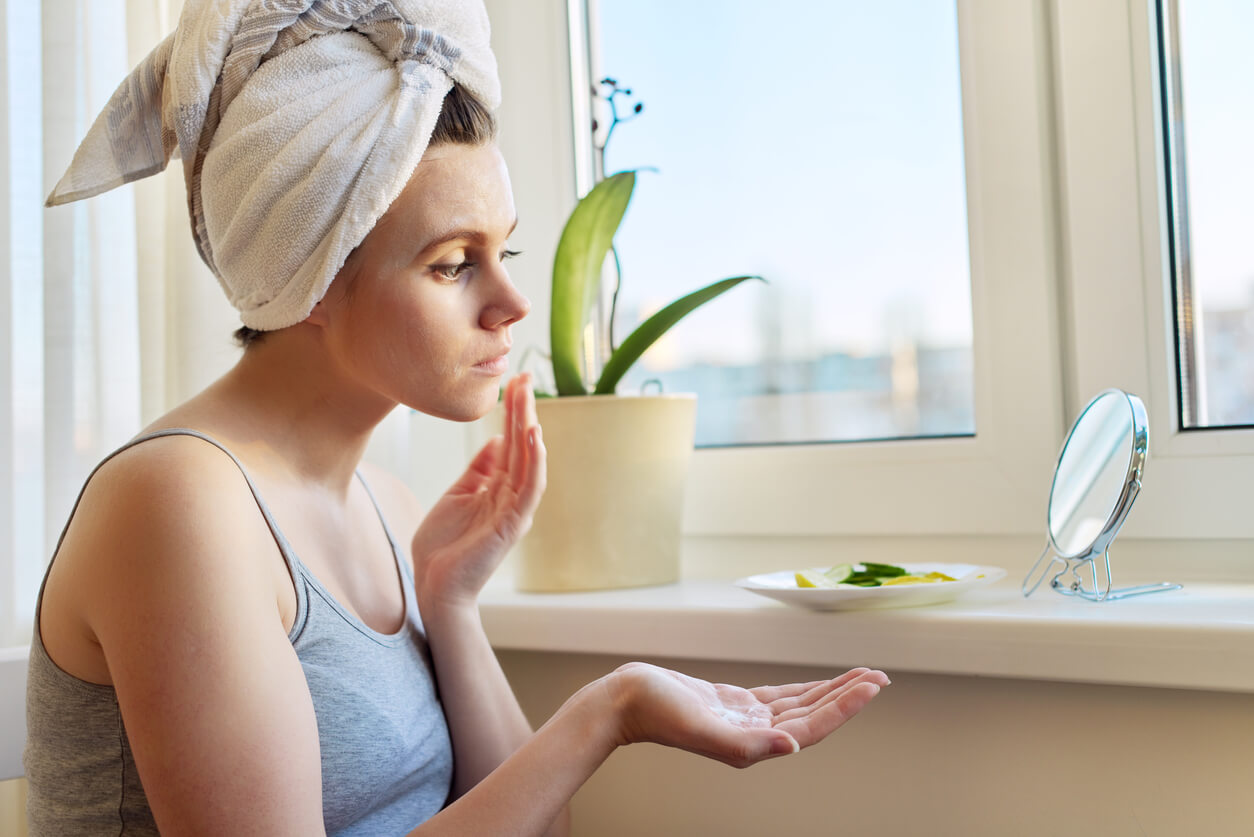 Une femme qui s'applique de la crème sur le visage.