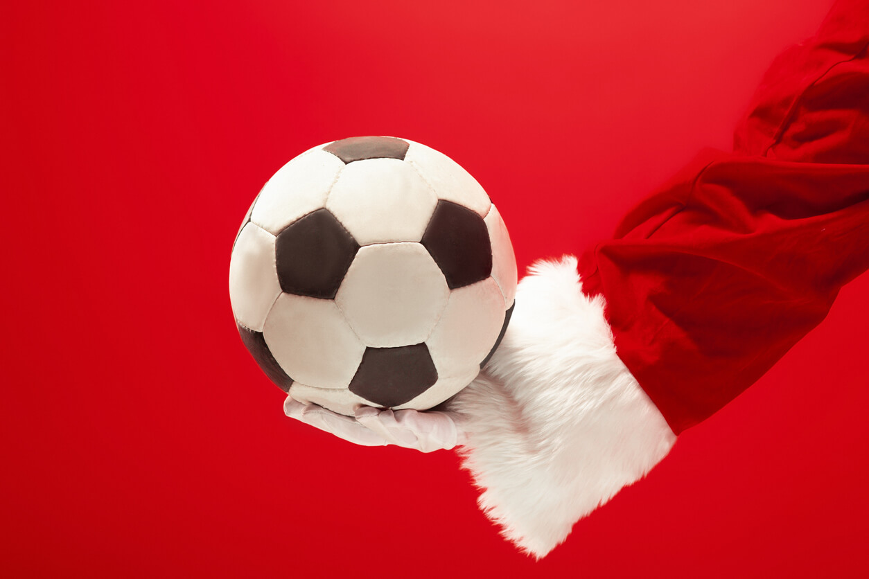 Un ballon de foot dans une main de père noël.