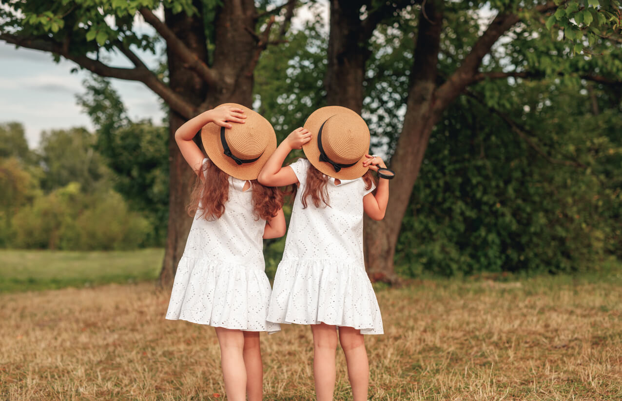 Twin girls dressed alike and posing the same way.