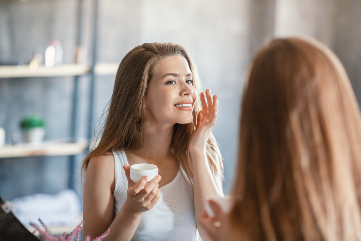 Une femme qui s'applique de la crème sur le visage;