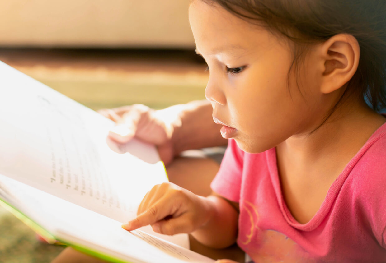 Une jeune fille qui commence à lire.
