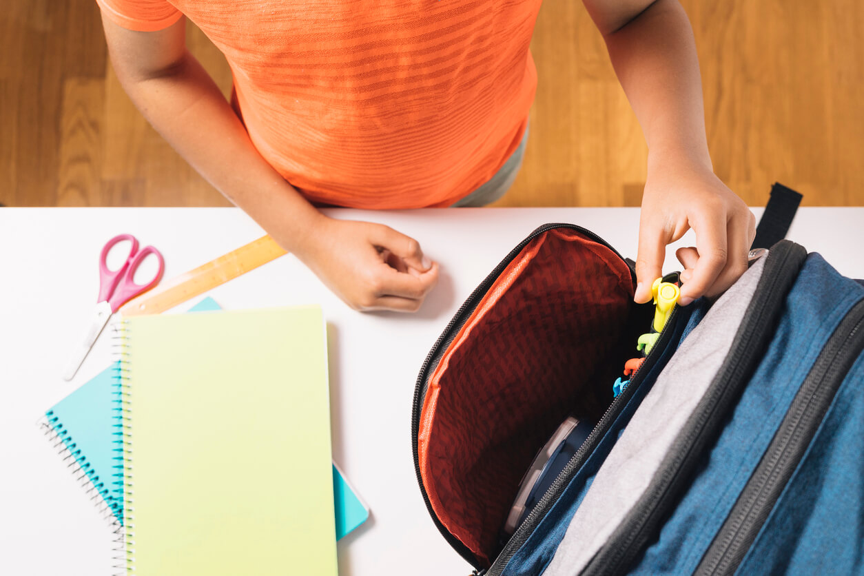 A child packing his bakcpack.