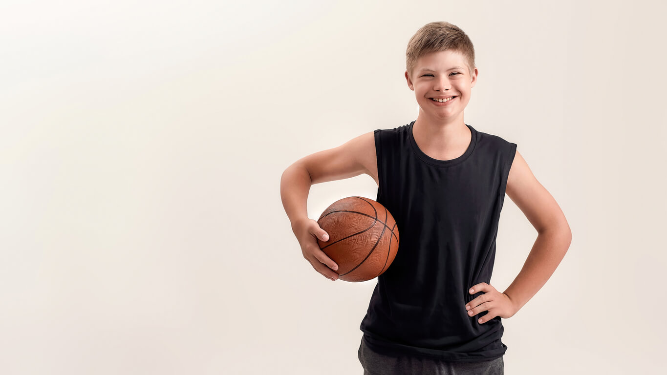 Un enfant trisomique avec un ballon de basket. 