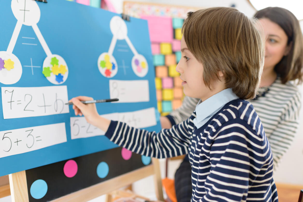 Un enfant qui fait des mathématiques au tableau de l'école.