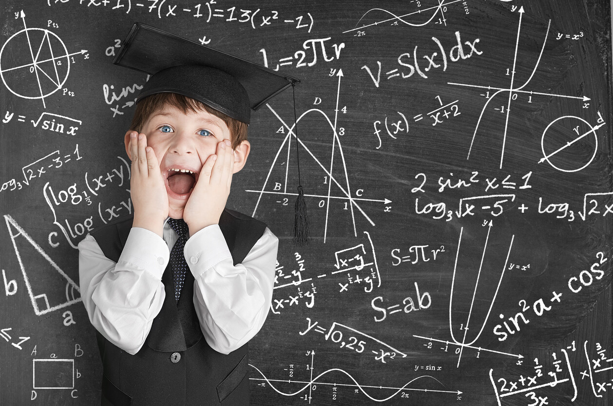 Un enfant devant un tableau de mathématiques.