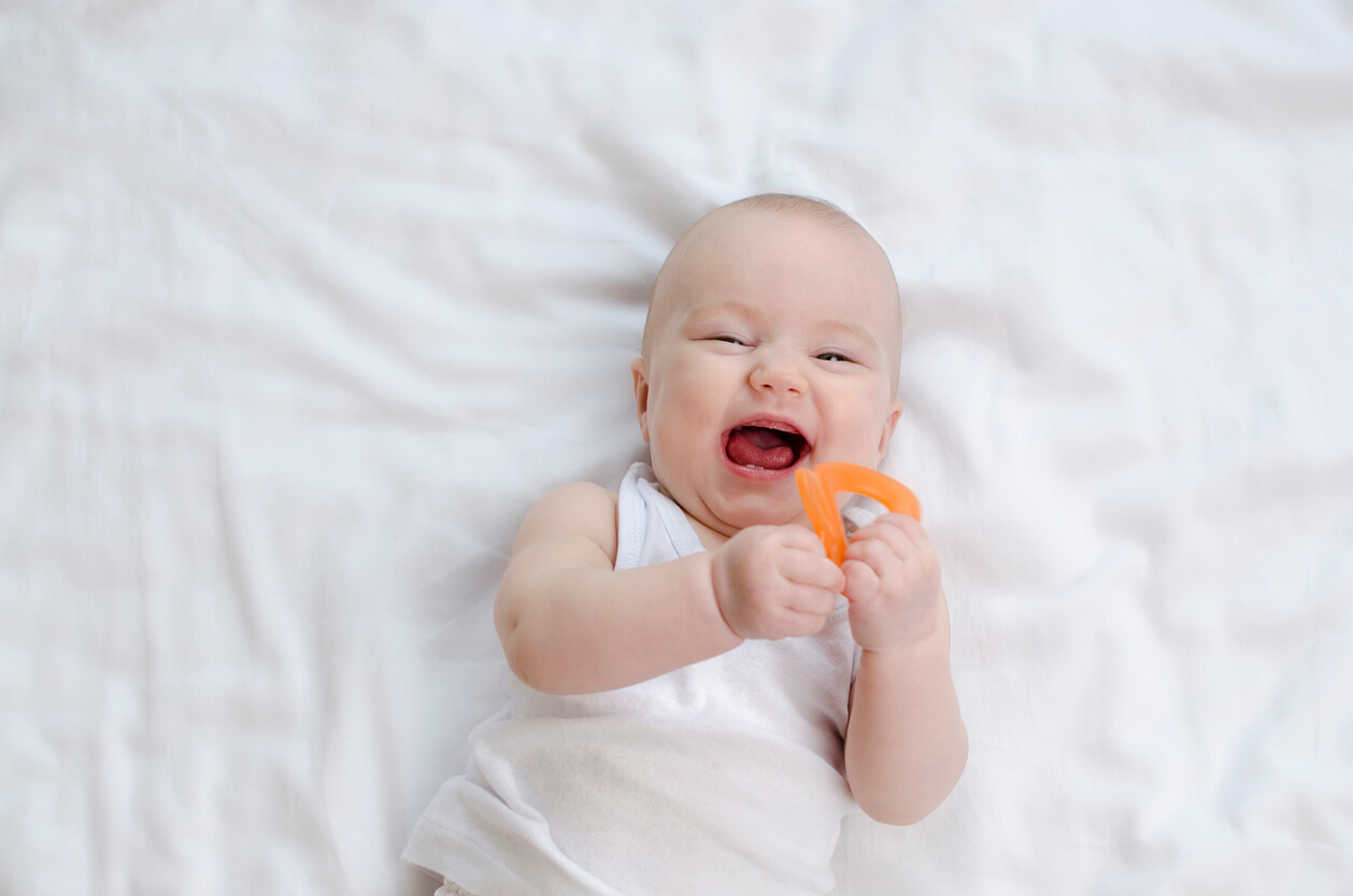 A baby holding a teether.