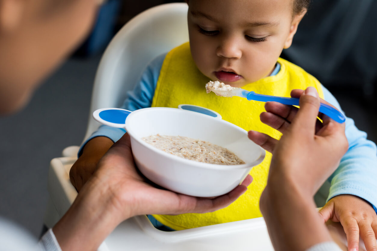 A baby eating oatmeal.