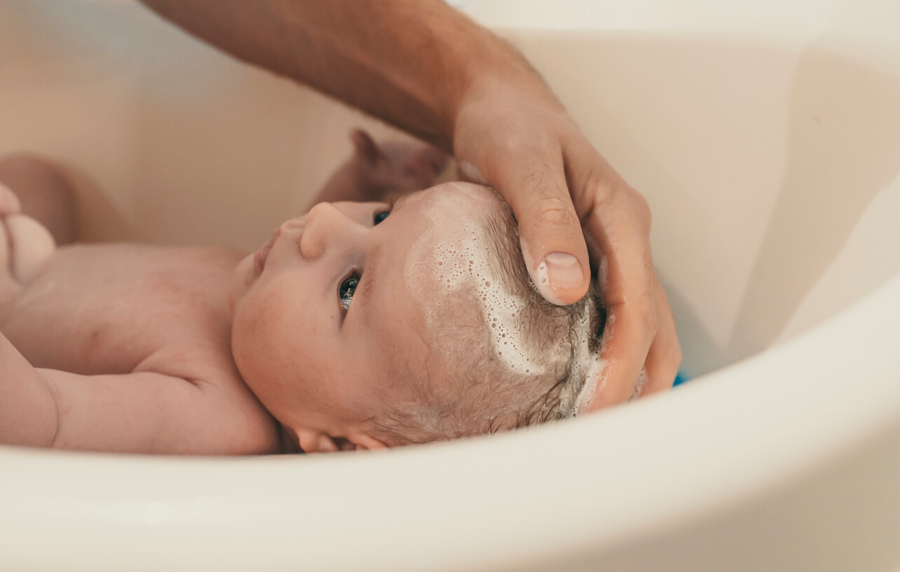 A person giving a baby a bath.