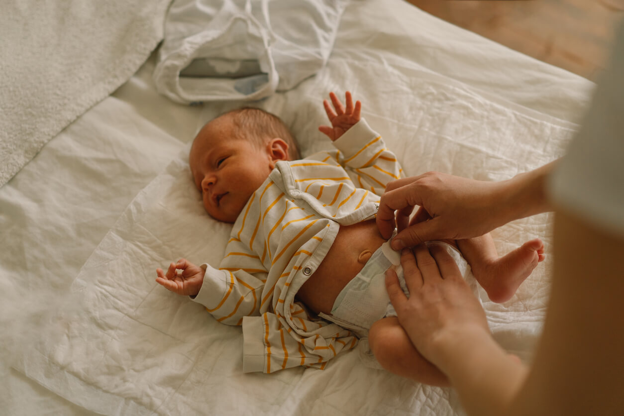 A parent changing a newborn baby's diaper.
