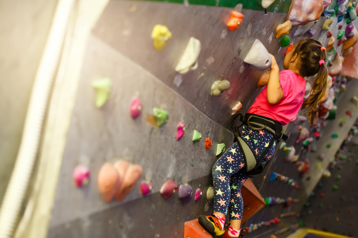 A young girl practicing wall climbing.